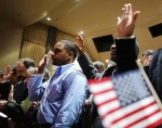 Over 90 immigrants representing over 40 countries take the oath of citizenship during a naturalization ceremony to become new citizens of the U.S. at Boston College in Chestnut Hill